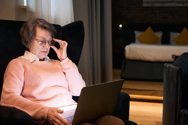 Ältere Dame Mit Brille Sitzt Mit Laptop Einem Bequemen Stuhl — Stockfoto