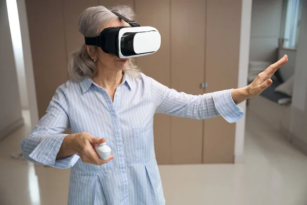 Mulher Cabelos Grisalhos Fica Sala Estar Óculos Realidade Virtual Ela — Fotografia de Stock
