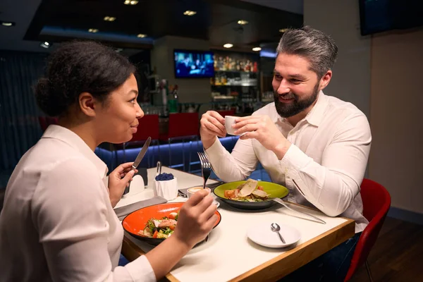 Male Cup Coffee Hands Smiling His Girlfriend Eating Salad Restaurant — Stock Photo, Image