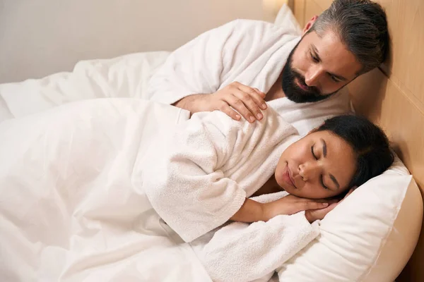 Opiekuńczy Młody Biały Mężczyzna Przytula Swoją Śpiącą Afroamerykankę Łóżku — Zdjęcie stockowe