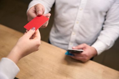 Beyaz erkek girişimcinin otelin resepsiyon görevlisinden anahtar kartını alırken çekilmiş bir fotoğrafı.