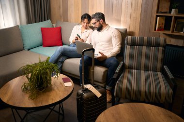 Genç bayan turist cep telefonuyla seyahat arkadaşına bir şey gösteriyor.