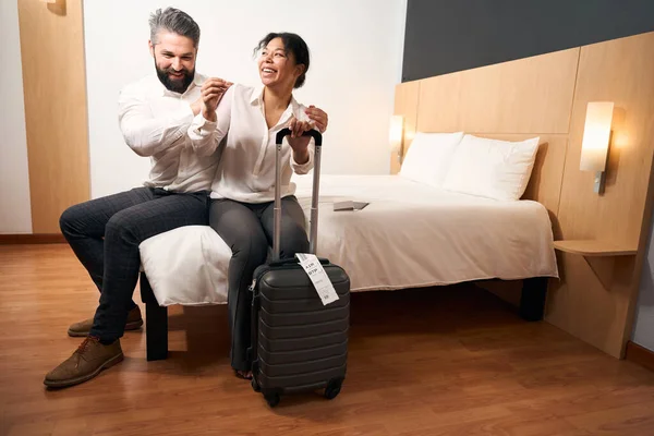 幸せな若いです女性とともに荷物と彼女の喜びコンパニオン上のベッドでホテルの部屋 — ストック写真