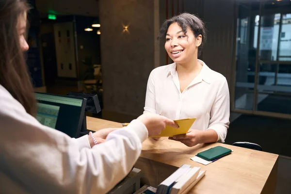 Smiling Young Woman Receiving Registration Form Female Receptionist Reception Desk — Stock Photo, Image