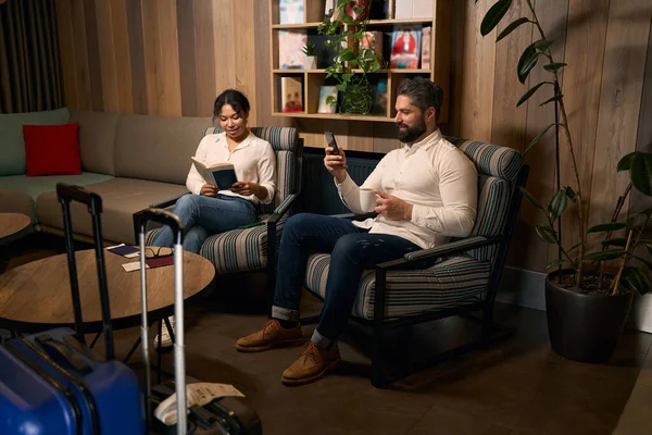 Woman Book Man Smartphone Coffee Cup Sitting Lounge Area — Stock Photo, Image