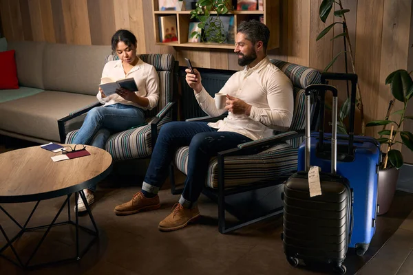 Vrouwelijk Leesboek Terwijl Man Sms Mobiele Telefoon Tijdens Koffiepauze Lounge — Stockfoto