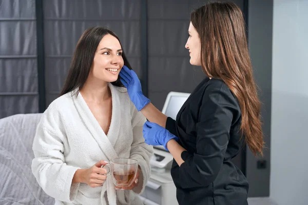 青い手袋と患者の顔に触れる保護スーツの医師 手順の準備 — ストック写真