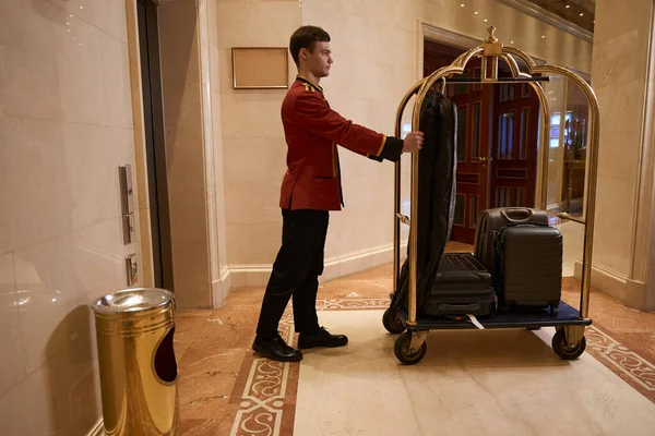 Jonge Hotelmedewerker Draagt Een Kar Met Bagage Langs Lobby Het — Stockfoto