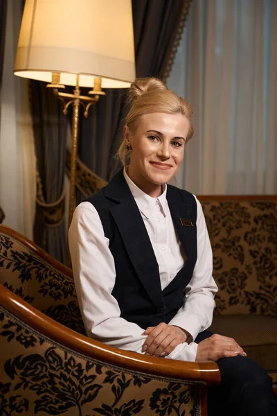 Lächelnder Hotelangestellter Sitzt Luxussessel Fenster Eine Frau Uniform Mit Abzeichen — Stockfoto
