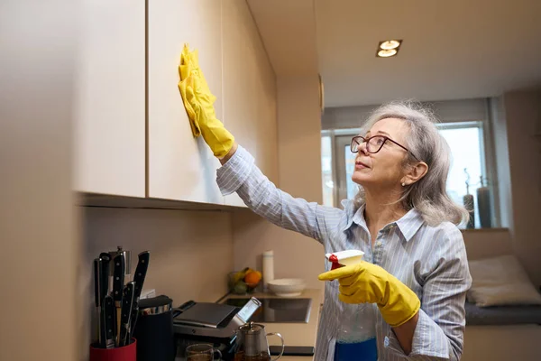 Intelligente Großmutter Mit Brille Und Schutzhandschuhen Wäscht Den Küchenschrank Sie — Stockfoto