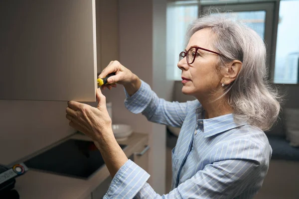 Abuela Inteligente Gafas Con Destornillador Está Reparando Gabinete Cocina Ella —  Fotos de Stock