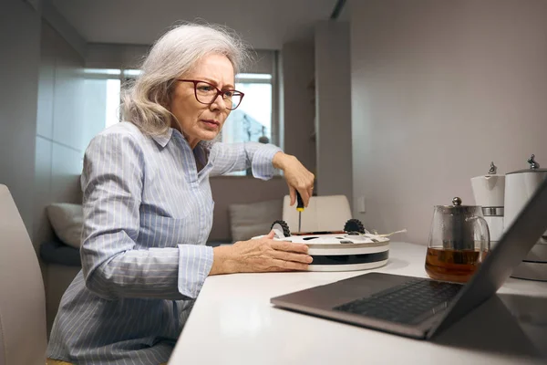 Ältere Frau Mit Brille Sitzt Vor Einem Laptop Mit Schraubenzieher — Stockfoto