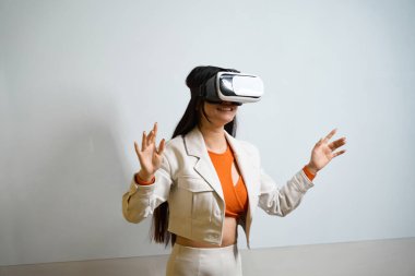 Sanal gerçeklik kulaklığıyla gülümseyen mutlu ofis çalışanı beyaz tahtayla duvarın karşısında duruyor.