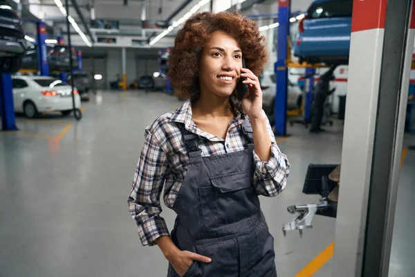 携帯電話で話している車の修理店の女性の自動車整備士 有料シャツの修理の女性 — ストック写真