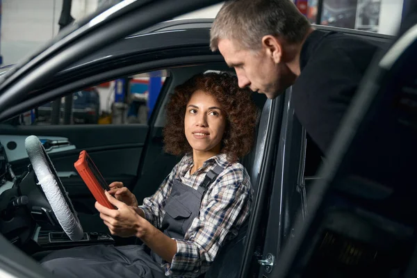 Multirracial Reparador Carro Feminino Sentado Carro Com Dispositivo Comunicando Com — Fotografia de Stock
