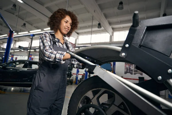 Sorrindo Mulher Multirracial Roupas Trabalho Reparando Roda Oficina Reparação Automóveis — Fotografia de Stock