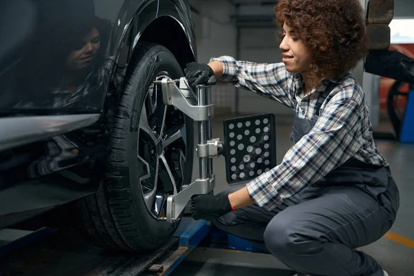 妇女汽车修理工在汽车修理厂修理车轮 妇女在工作服 — 图库照片