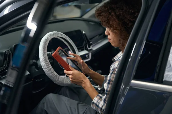Curly Multirracial Mulher Auto Mecânico Senta Carro Com Dispositivo Para — Fotografia de Stock