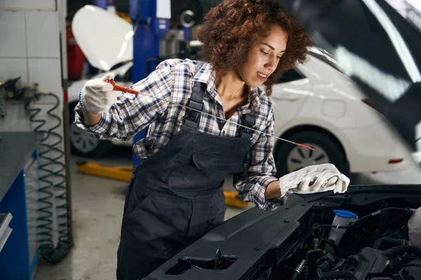 可爱的年轻维修工检查车内的油位 这个女人穿着舒适的工作服工作 — 图库照片