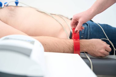 Hasta erkek elinde EKG elektrotlarının kesilmiş fotoğrafı. Klinikte elektrokardiyogram ve EKG prosedürü