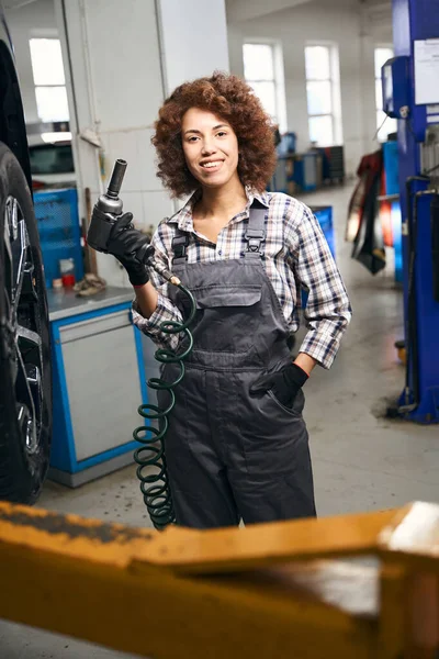 Szczęśliwa Młoda Kobieta Trzyma Pneumatyczny Śrubokręt Rękach Pracuje Warsztacie Samochodowym — Zdjęcie stockowe