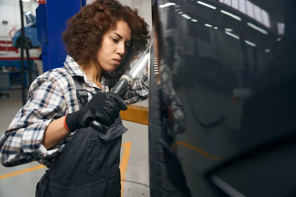 多种族汽车修理工穿着格子衣服检查汽车车轮 妇女使用特殊灯 — 图库照片
