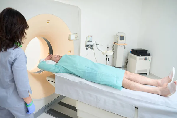 Elleri Havada Yetişkin Bir Adam Hastanenin Teşhis Bölümünde Tomografi Çekiliyor — Stok fotoğraf