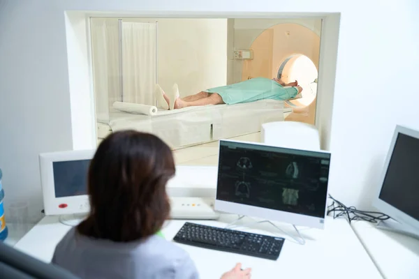 Female doctor performing MRI diagnostics for male patient in a modern clinic