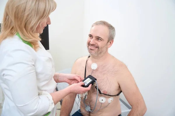 Dokter Perempuan Tangan Menerapkan Holter Monitor Jantung Pada Dada Laki — Stok Foto
