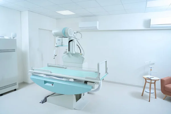 X-ray room with modern X-ray machine in clinic. Copy space. Medicine and diagnostic concept