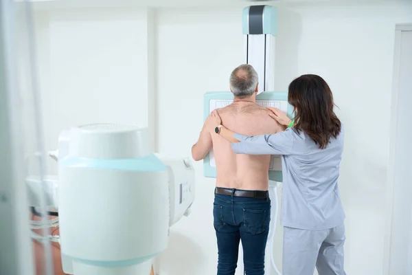 Kobieta Profesjonalny Radiolog Pomaga Męskiemu Pacjentowi Rentgenem Klatki Piersiowej Klinice — Zdjęcie stockowe