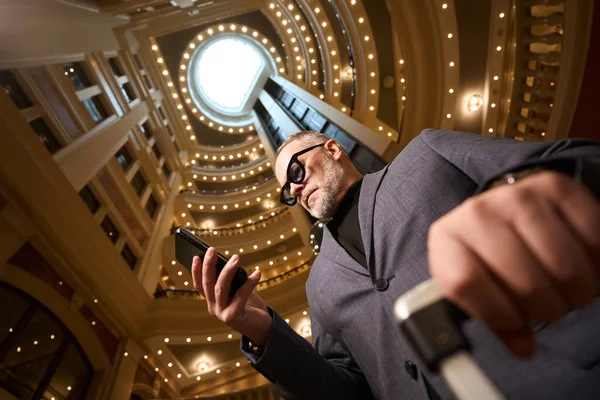 Впечатляющий Самец Держит Руках Телефон Путешественник Останавливается Шикарном Отеле — стоковое фото
