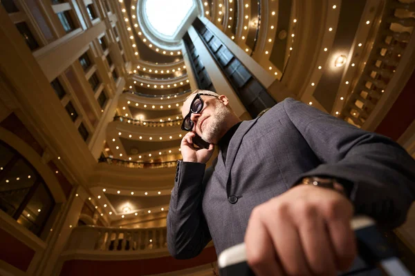 Gray Haired Man Talking Phone Hotel Lobby Traveler Checks Luxury — Stock Photo, Image