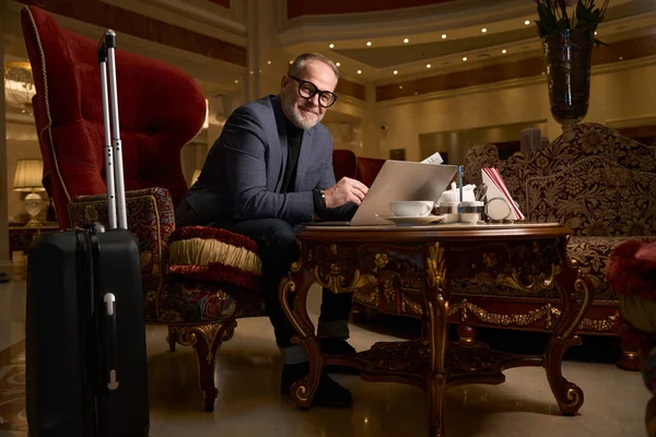 Zufriedener Mann Mit Brille Steht Mit Laptop Aufenthaltsraum Daneben Ein — Stockfoto