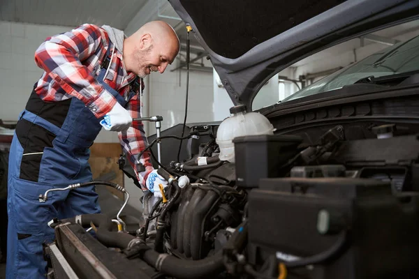 Trabalhador Uma Oficina Reparação Automóvel Repara Carro Homem Usa Uma — Fotografia de Stock