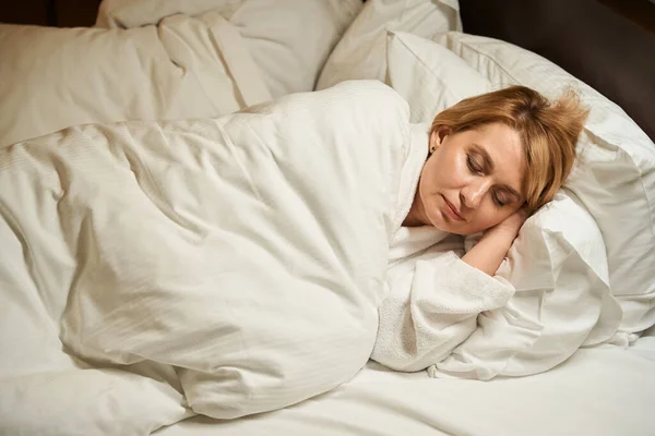 美しい中年の女性は柔らかい枕の上で甘い昼寝をしている 彼女の夫は近くで寝ている — ストック写真