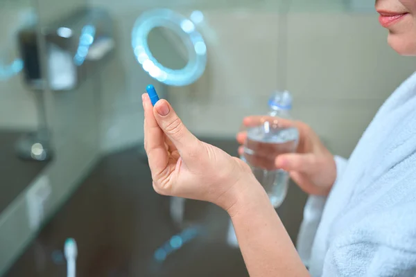 Nainen Pitää Pilleriä Pullo Vettä Käsissään Nainen Kylpyhuoneessa — kuvapankkivalokuva