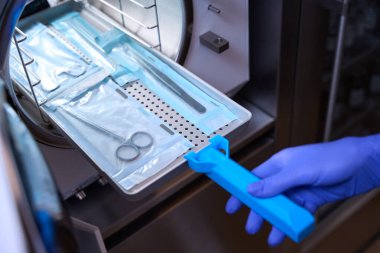Tıbbi aletler özel bir ızgarada yatıyor ve sterilizasyon için otoklavın içine yerleştiriliyor.