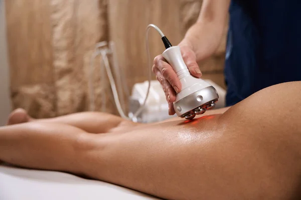 在温泉沙龙的臀部和大腿区域对一位女士做射频提升手术的专家 — 图库照片