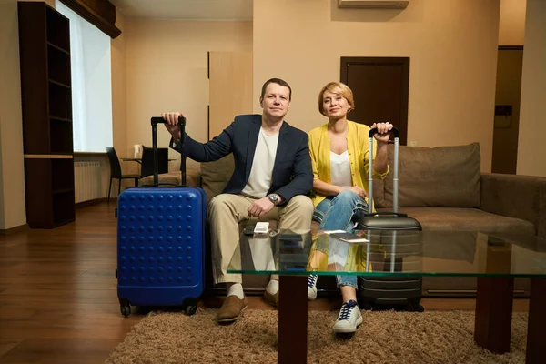 Podróżujący Para Podróży Ubrania Siedzieć Nowoczesnym Pokoju Hotelowym Mają Walizki — Zdjęcie stockowe