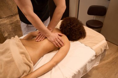 Masör spa salonunda kadınlara rahatlatıcı ve tonik masajı yapıyor.