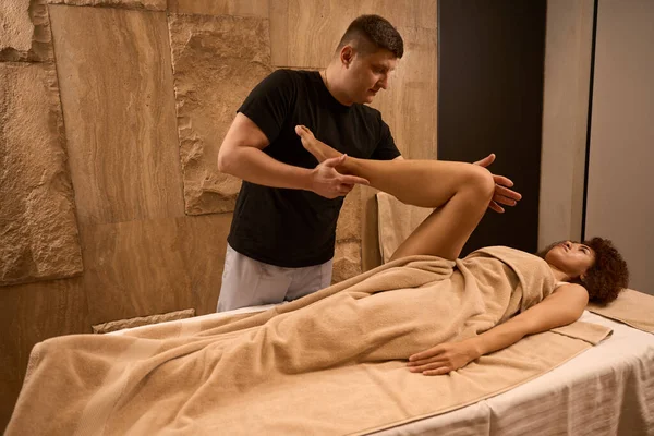 Male Osteopath Checking Reflexes Flexing Leg Young Woman She Lying — Stock Photo, Image