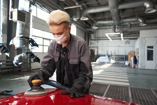 보호용 마스크를 착용하고 자동차를 보호하는 자동차 수리공 개조하는 업소에서 기계를 — 스톡 사진