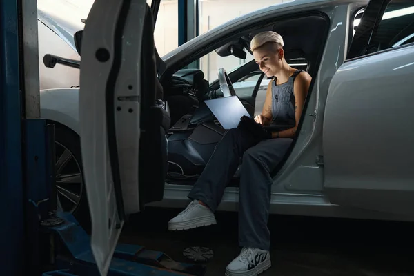 Junge Reparaturfrau Sitzt Mit Laptop Autoinnenraum Und Tippt Die Frau — Stockfoto