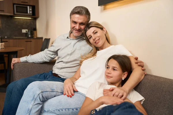 Esposo Esposa Con Hija Sentados Sofá Posando Cámara Habitación Moderna —  Fotos de Stock