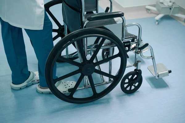 Infirmière Uniforme Tient Dans Couloir Hôpital Avec Fauteuil Roulant Chaise — Photo