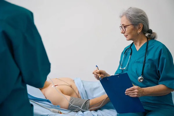 Vrouwelijke Medisch Werker Zit Buurt Van Een Patiënt Met Een — Stockfoto