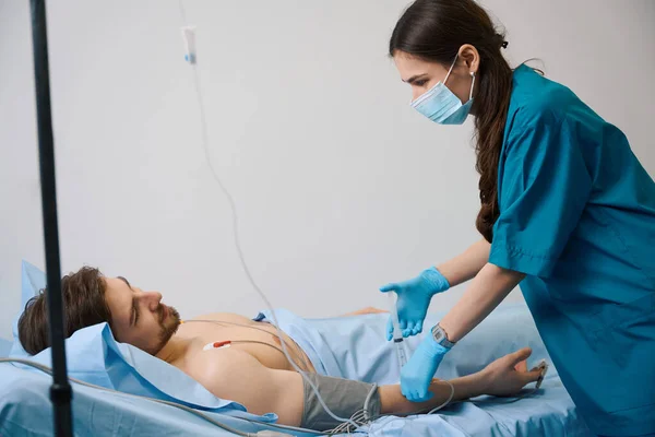 Enfermera Joven Inyecta Medicina Goteo Hombre Está Conectado Holter — Foto de Stock