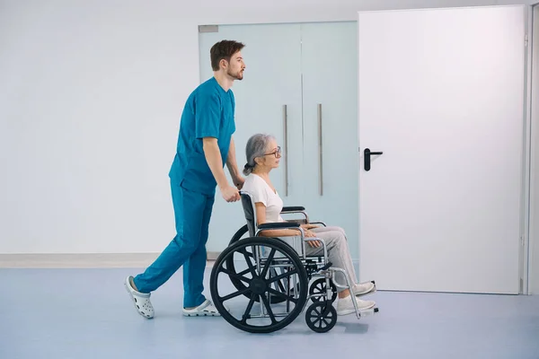 Pflegekraft Begleitet Eine Ältere Dame Rollstuhl Das Zimmer Ist Hell — Stockfoto