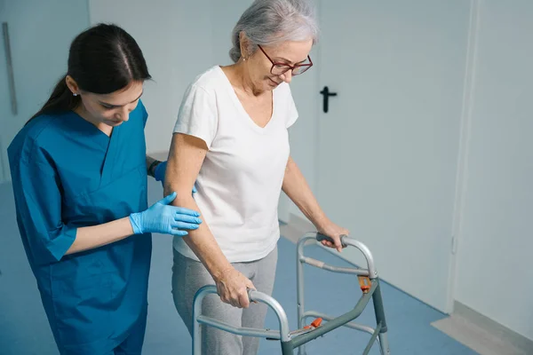 Infermiera Premurosa Accompagna Paziente Anziano Una Donna Muove Con Deambulatore — Foto Stock